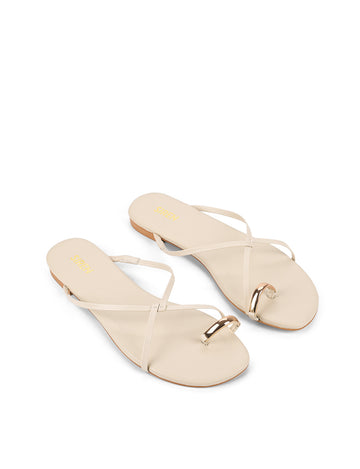 Women's flat strappy sandal with gold metallic toe ring in bone leather