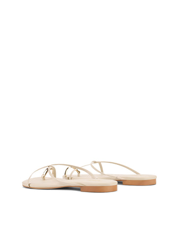 Women's flat strappy sandal with gold metallic toe ring in bone leather