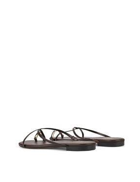 Women's flat strappy sandal with gold metallic toe ring in chocolate brown leather