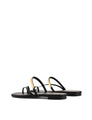 Women's black leather flat slide with gold metallic embellishment, dainty straps and toe ring