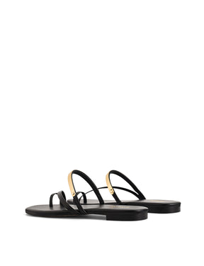 Women's black leather flat slide with gold metallic embellishment, dainty straps and toe ring
