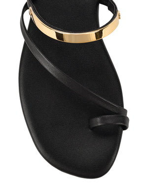 Women's black leather flat slide with gold metallic embellishment, dainty straps and toe ring