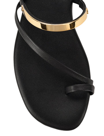 Women's black leather flat slide with gold metallic embellishment, dainty straps and toe ring