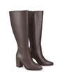 Women's leather knee high boots with stacked leather block high heel and pointed toe and inner zipper.