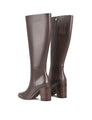 Women's leather knee high boots with stacked leather block high heel and pointed toe and inner zipper.