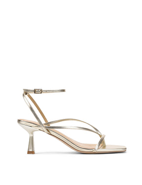 Gold high-heeled sandal on a white background