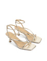 Gold high-heeled sandals on a white background