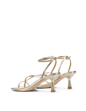 Gold high-heeled sandal on a white background